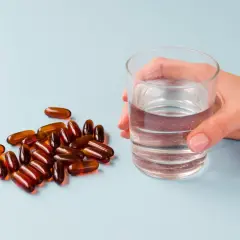 Kapsułki i szklanka wody. Suplementy z **jodem na co pomagają**? Wspierają tarczycę i metabolizm.