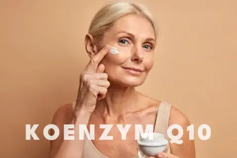 Kobieta aplikuje krem z koenzymem Q10 na skórę wokół oczu. Koenzym Q10 na co? Na odmłodzenie i regenerację.