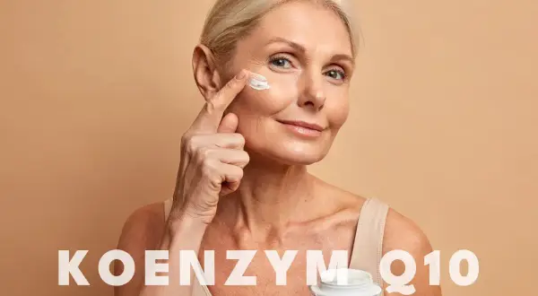 Kobieta aplikuje krem z koenzymem Q10 na skórę wokół oczu. Koenzym Q10 na co? Na odmłodzenie i regenerację.
