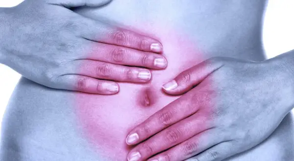 Dłonie na brzuchu, czerwony obszar bólu. Helicobacter pylori może wywoływać objawy psychiczne, takie jak niepokój.